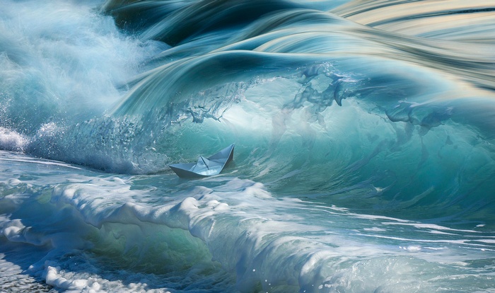 Paper boat in a large ocean wave