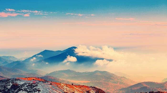 Mountains shrouded in clouds during sunset
