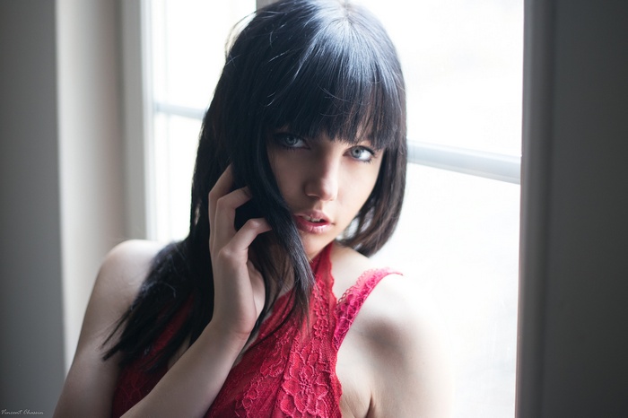 Woman with dark hair and blue eyes wearing red lace