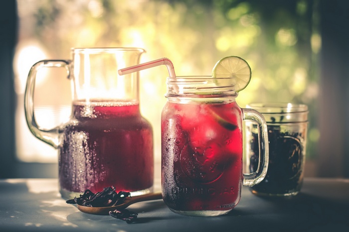 Hibiscus tea in pitcher and mason jar with lime