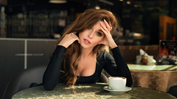 Woman with green eyes and pink lipstick in black clothing