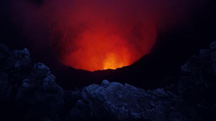 Volcanic eruption with lava and smoke in a crater