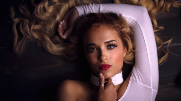 Woman with blonde hair and red lipstick lying down