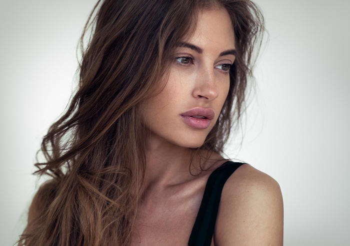 Woman with long brown hair looking away