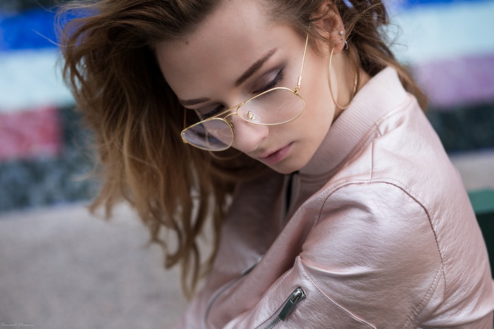 Woman with blonde hair wearing glasses and a pink jacket