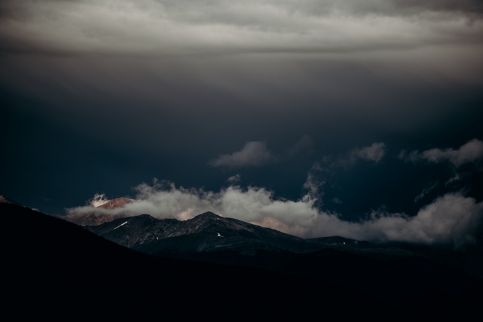 Dark stormy clouds over rugged mountains