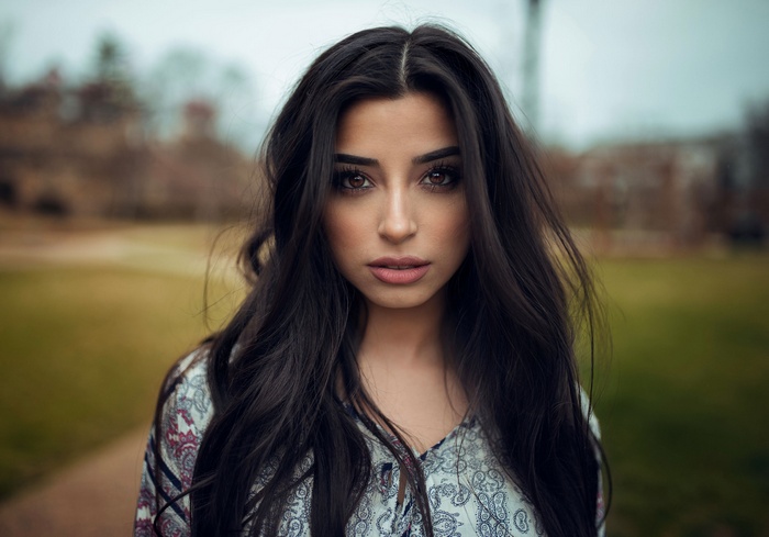 Woman with long dark hair in a patterned shirt