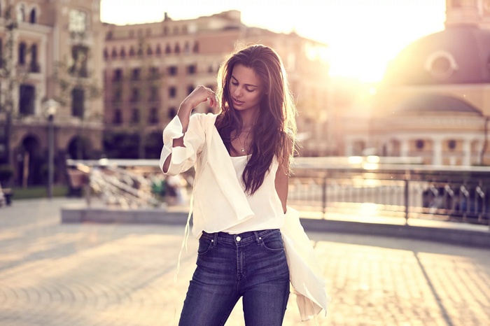 Woman in jeans and white top outdoors