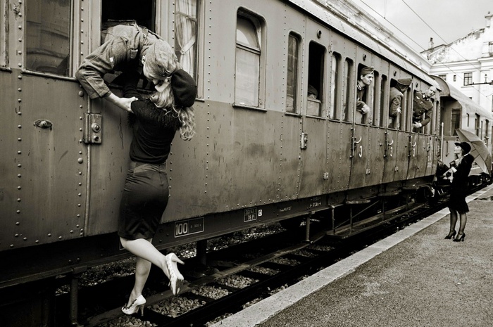 Couple kissing at a vintage train station