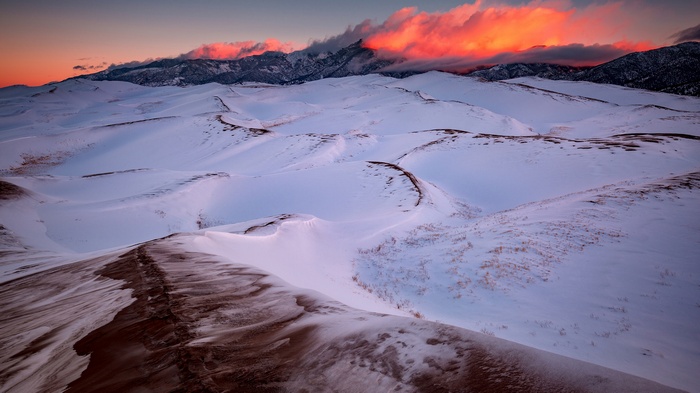 Sunset over snow-covered dunes in Great Sand Dunes National Park