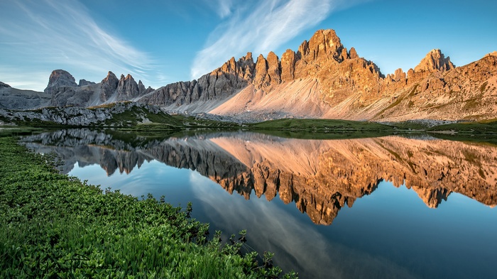 Mountain range reflected in a calm lake at sunrise