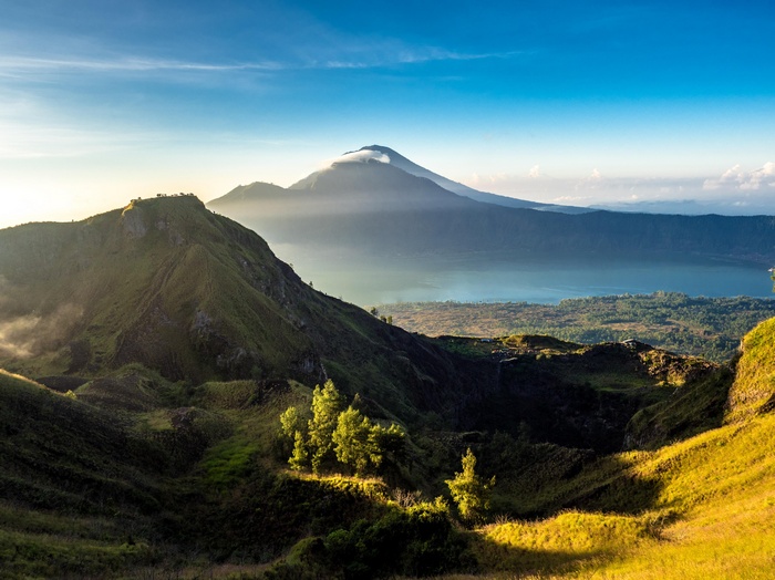 Volcanic landscape with mountains and lake at sunrise
