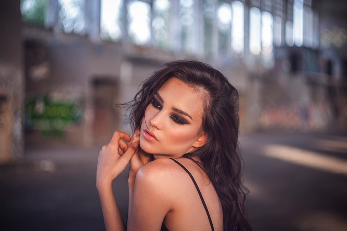 Woman with dark eye makeup looking away