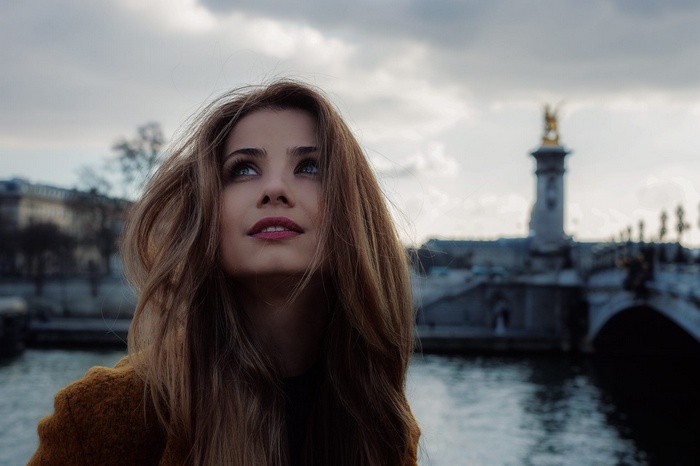 Woman looking up on a bridge in Paris, France