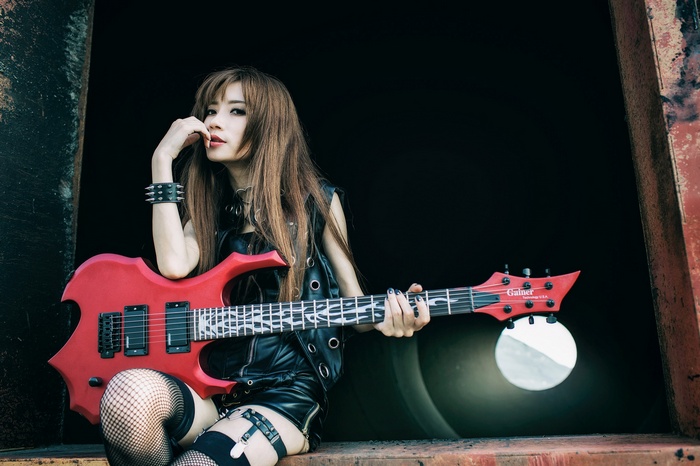 Asian woman with red electric guitar