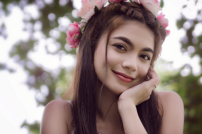 Woman with flower crown smiling outdoors