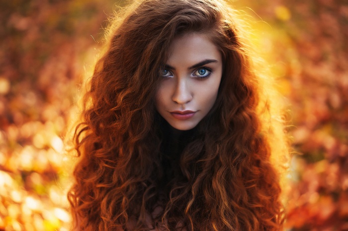 Portrait of a woman with wavy red hair and blue eyes