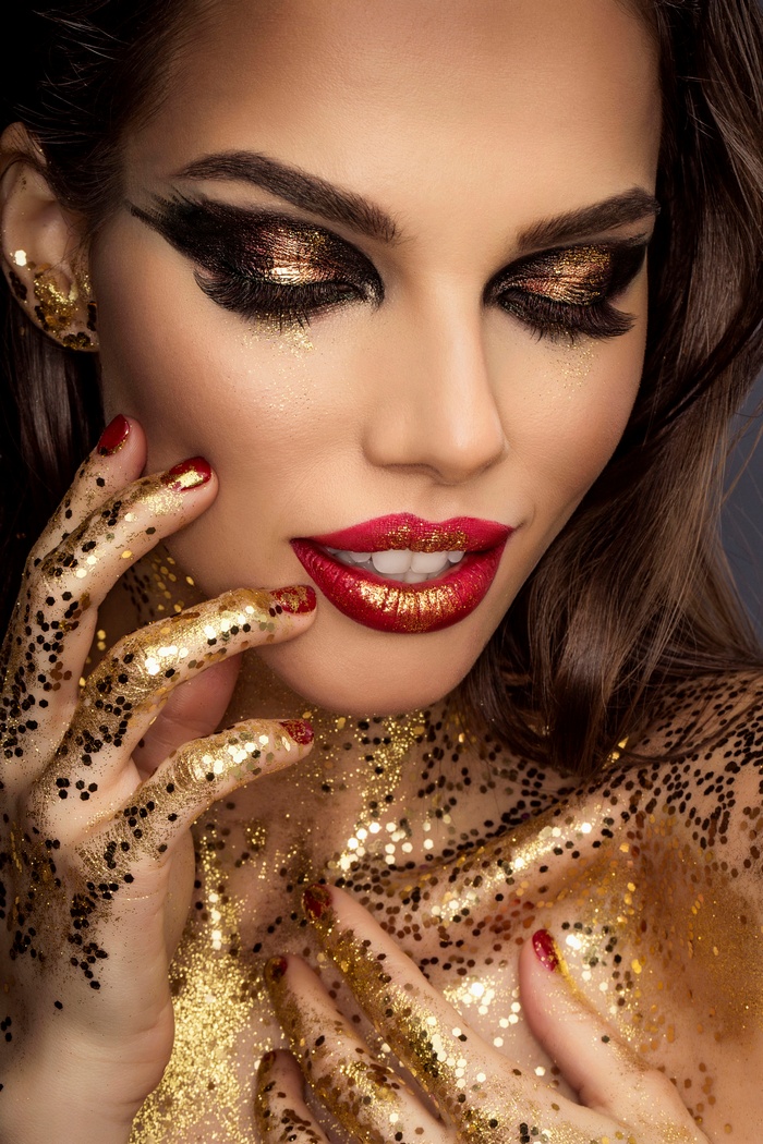 Woman with gold glitter and red lipstick