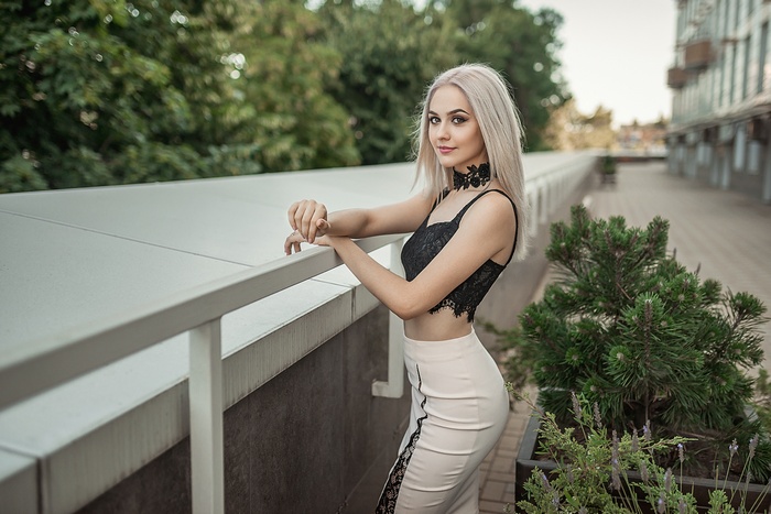 Woman with blonde hair wearing a black choker and top