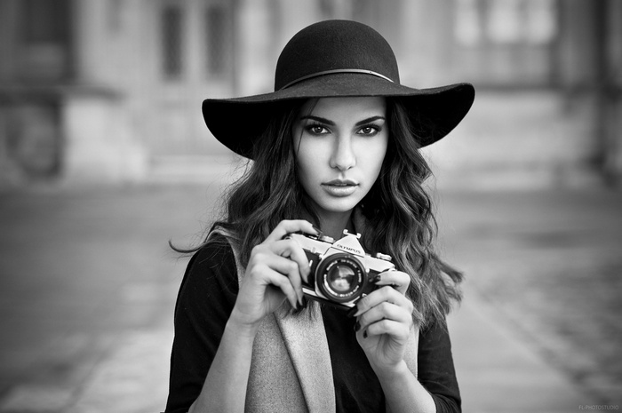 Woman in hat holding Olympus camera