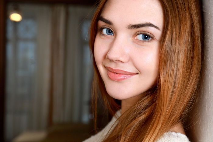Young woman with blue eyes and long auburn hair