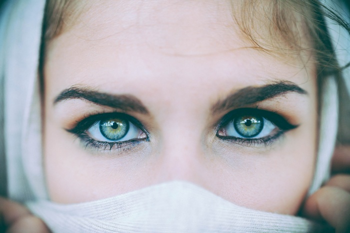 Close-up of a woman's eyes with a white scarf