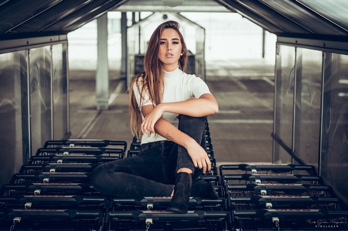 Woman with long hair sitting on shopping carts