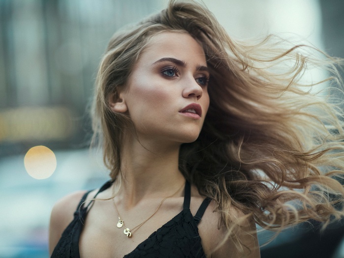 Woman with blonde hair and blue eyes wearing a necklace