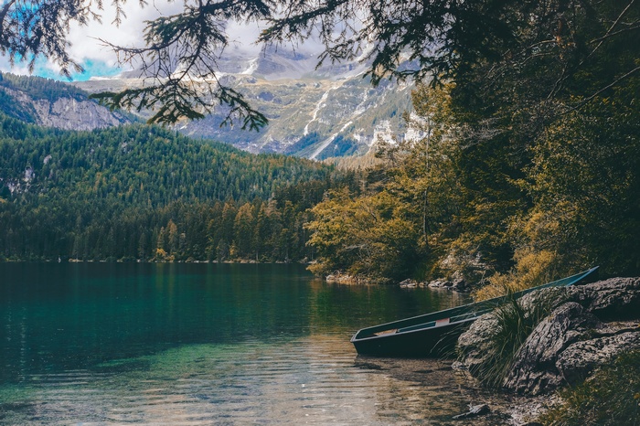 Boat on a rocky shore of a lake with mountains