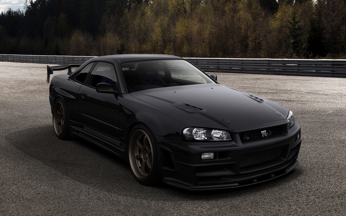Black Nissan Skyline GT-R R34 sports car on a track