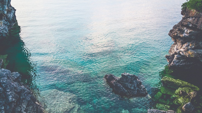 Clear turquoise water by rocky cliffs