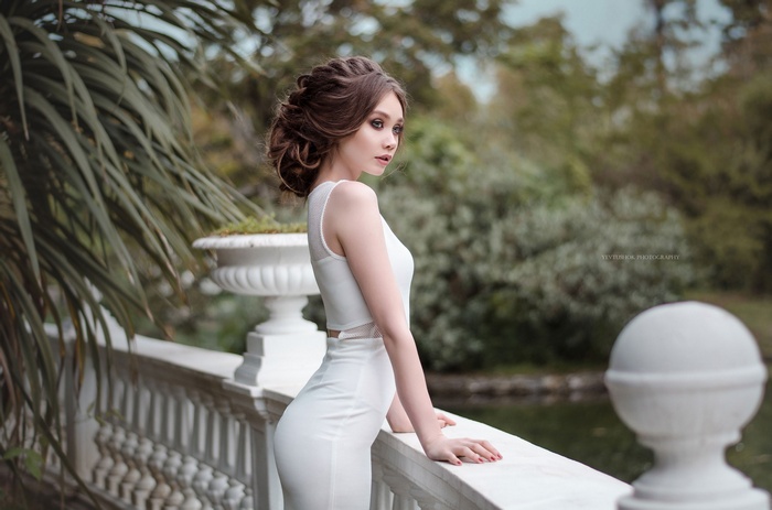 Woman in white dress on a balcony
