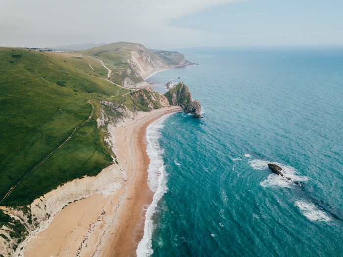 Aerial view of a sandy beach and turquoise ocean waves