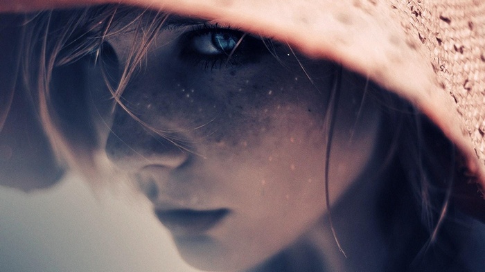 Close-up of a young woman with freckles and blue eyes