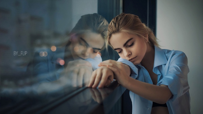 Woman with closed eyes leaning on window