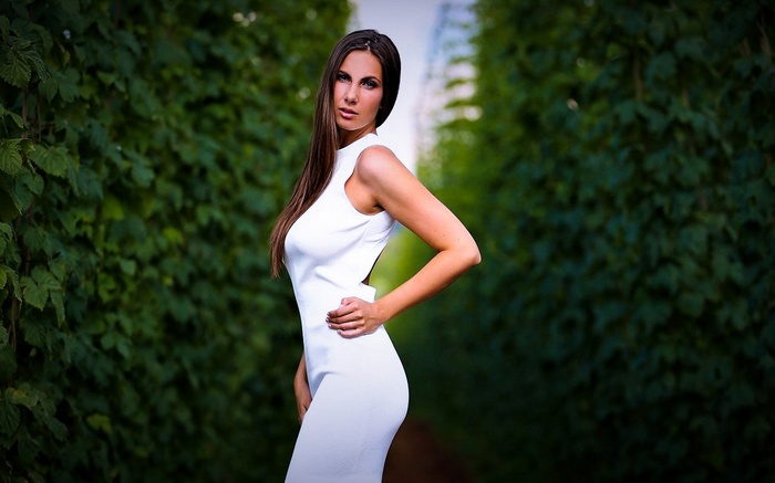 Conny Lior posing outdoors in a white dress