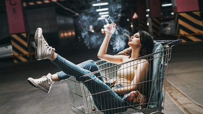 Woman smoking in a shopping cart