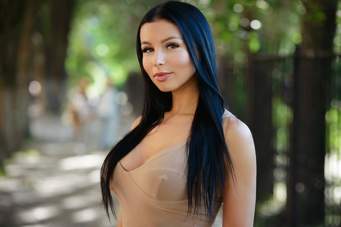 Woman with long black hair in a beige dress