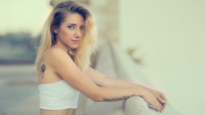 Portrait of a blonde woman with tattoos outdoors