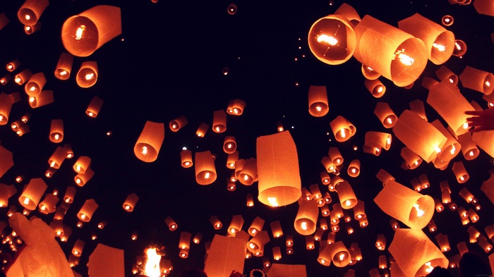 Many sky lanterns floating in the night sky
