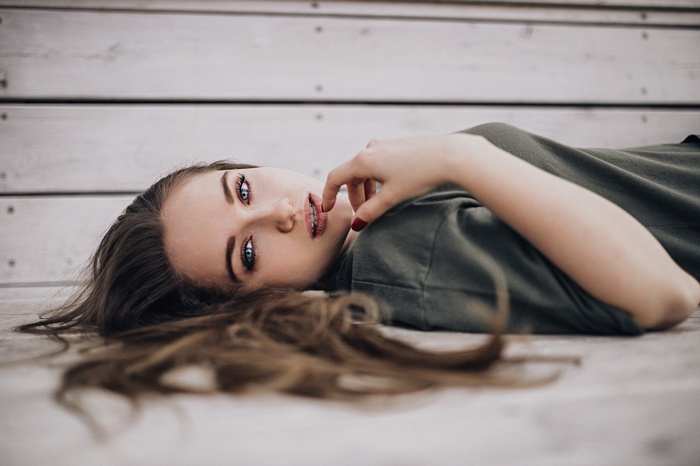 Woman with blue eyes lying on wooden planks