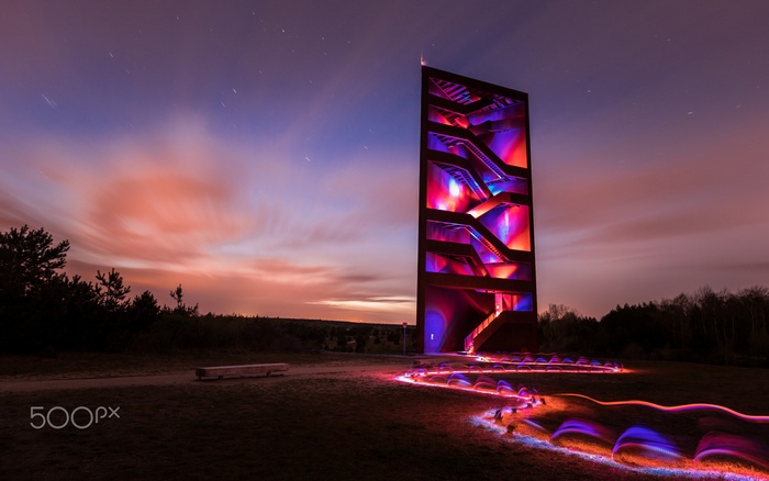 Illuminated Tower with Light Trails at Dusk