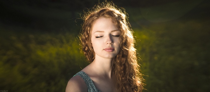 Woman with red curly hair and closed eyes