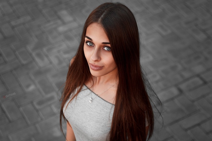 Woman with long brown hair wearing a grey top
