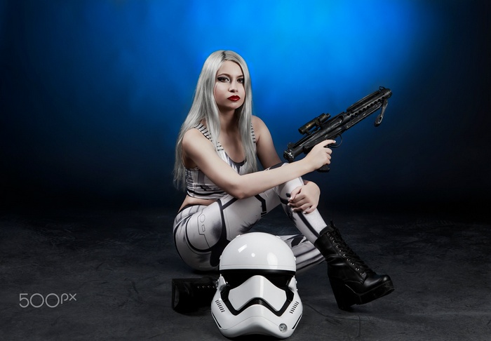 Woman in Stormtrooper Cosplay with Blaster and Helmet