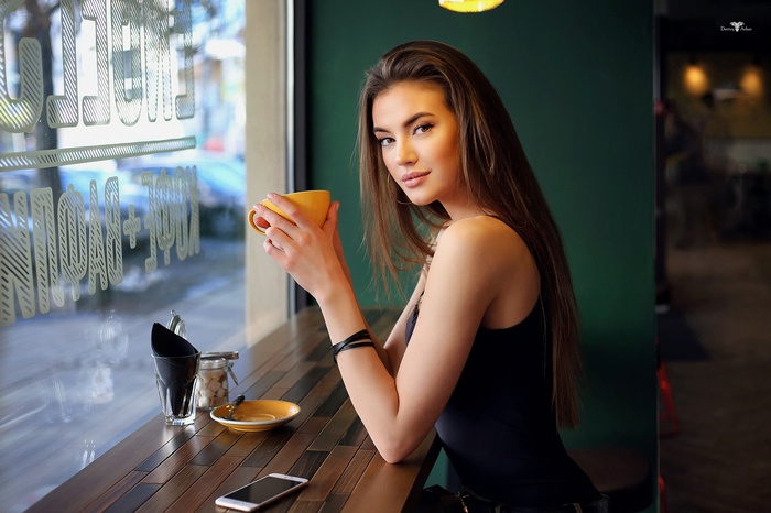 Woman holding a coffee cup in a cafe
