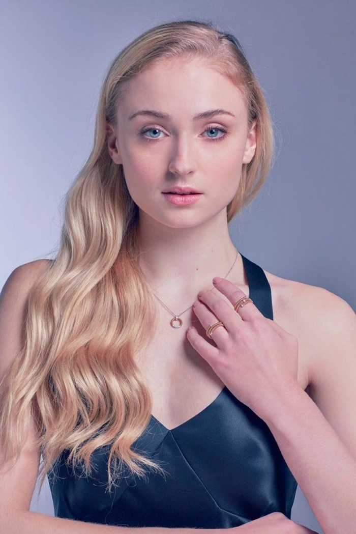 Sophie Turner wearing a black dress and jewelry