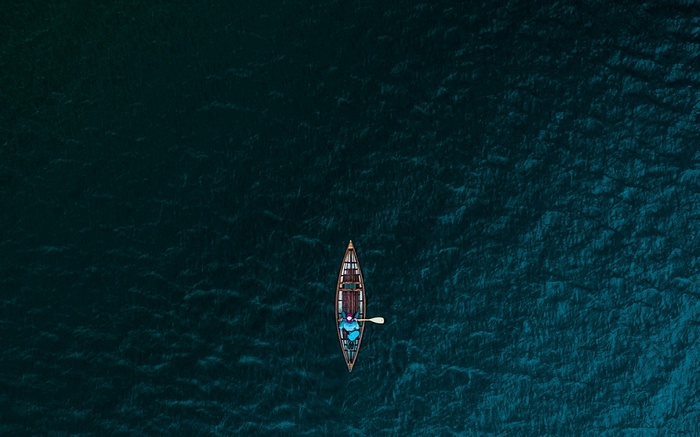 Person in canoe paddling on dark water