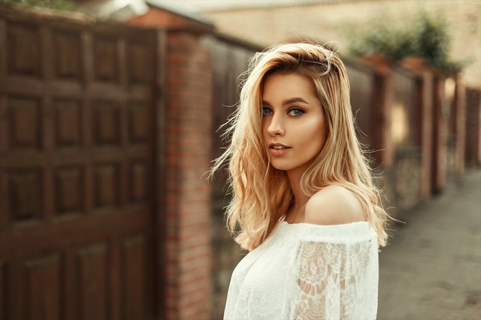 Woman with blonde hair in a white lace top