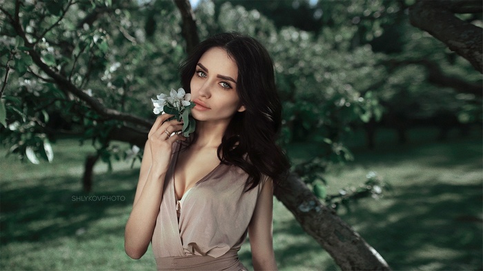 Portrait of a woman with flowers by Nikolay Shlykov